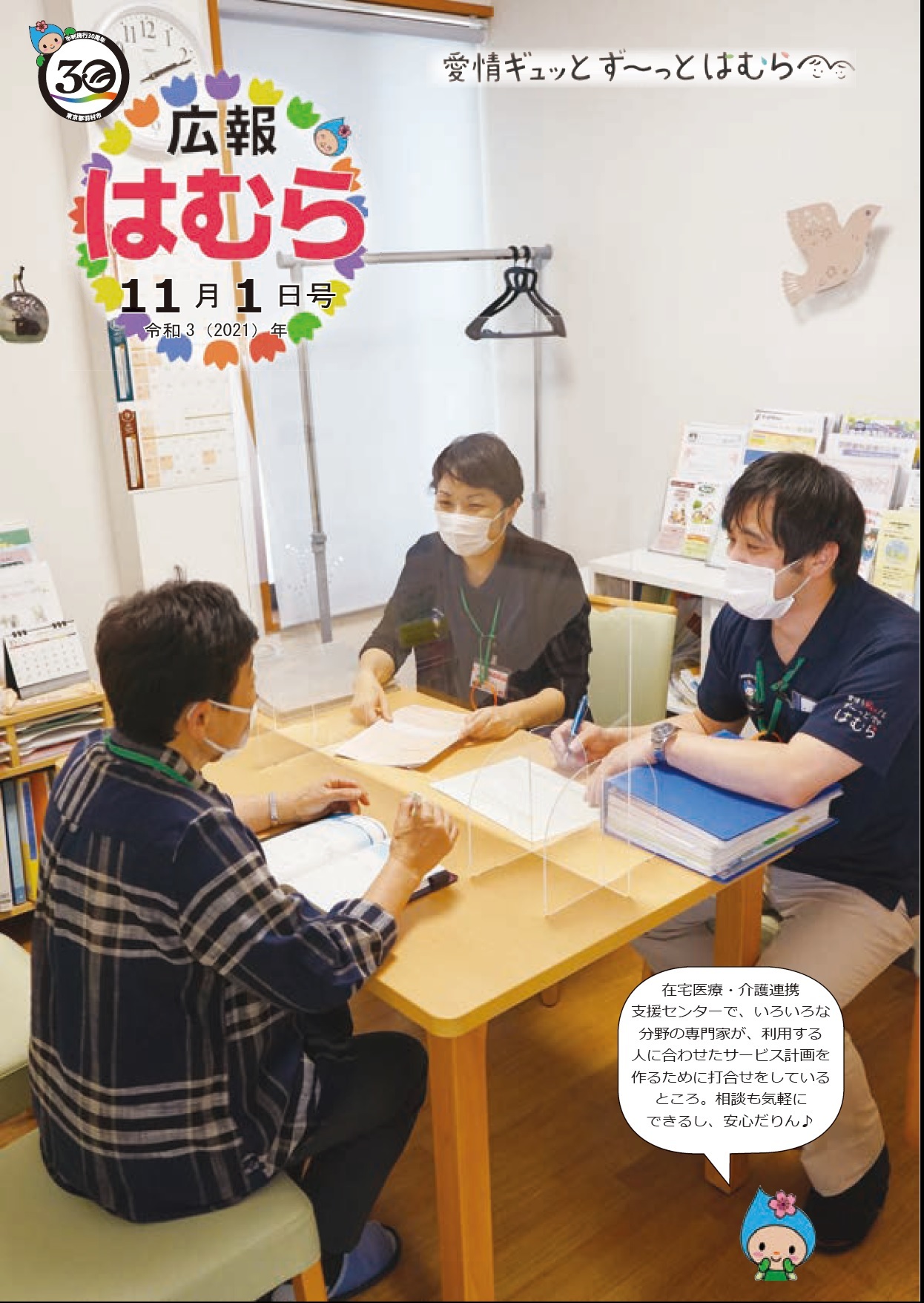 広報はむら11月1日号No.1056表紙　在宅医療・介護連携支援センターで打合せをしている様子