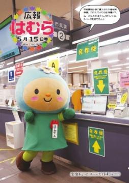 広報はむら5月15日号No.1069表紙 市民課受付係で自動発券機をPRするはむりん
